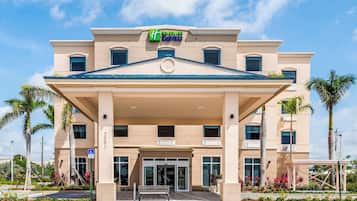Edifício Holiday Inn Express com entrada central, várias janelas e telhado plano.