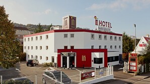 Een hotel met een gevel in rood en wit, een duidelijke ingang en een bord dat een lobby aangeeft.