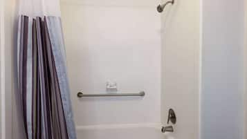 A shower area with a grab bar, a white bathtub, and a shower curtain.
