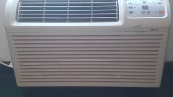 Aire condicionador portàtil blanc amb un panell de control que mostra les temperatures i les opcions de mode.