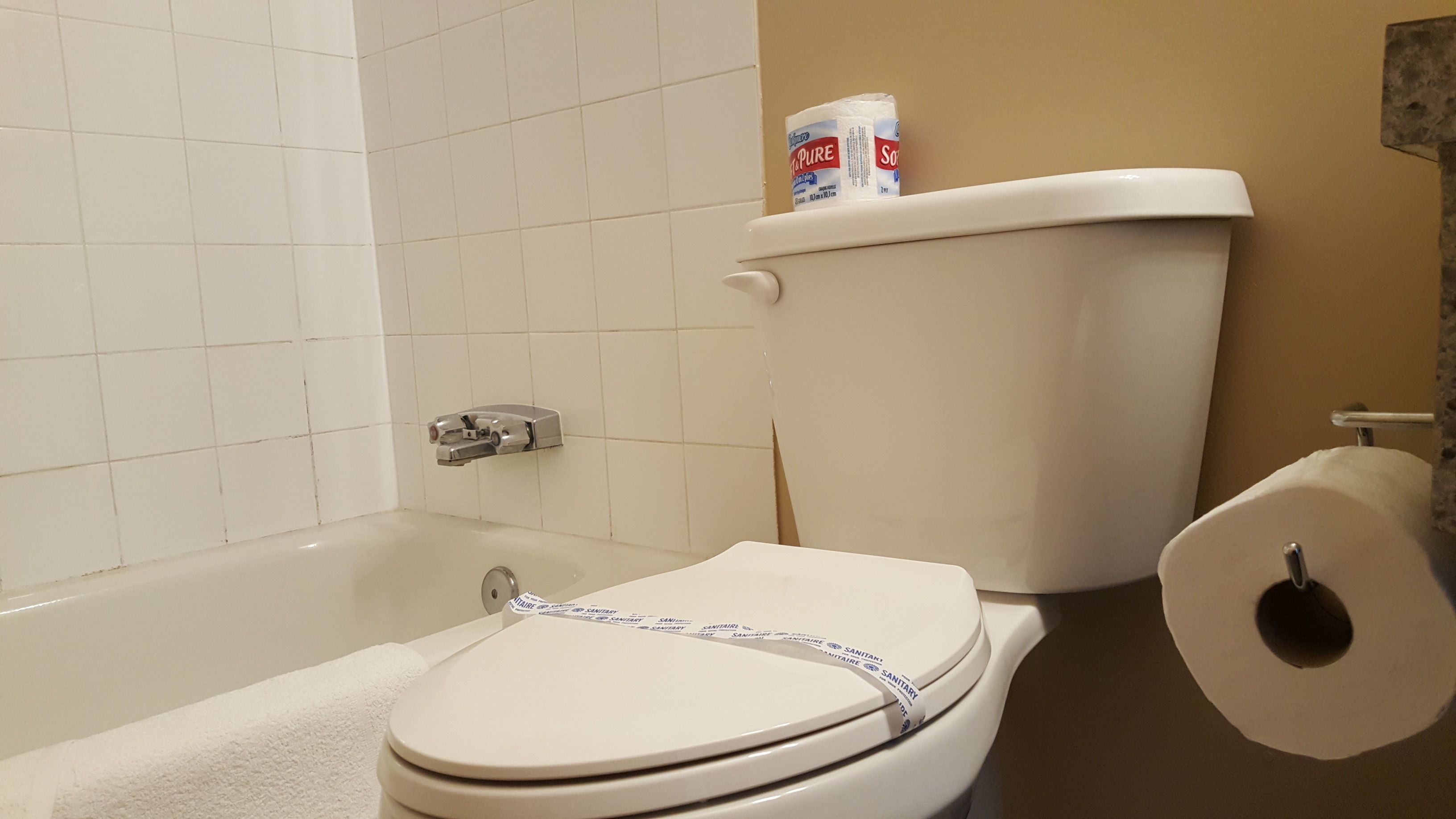 Un baño con inodoro, rollo de papel higiénico y bañera.