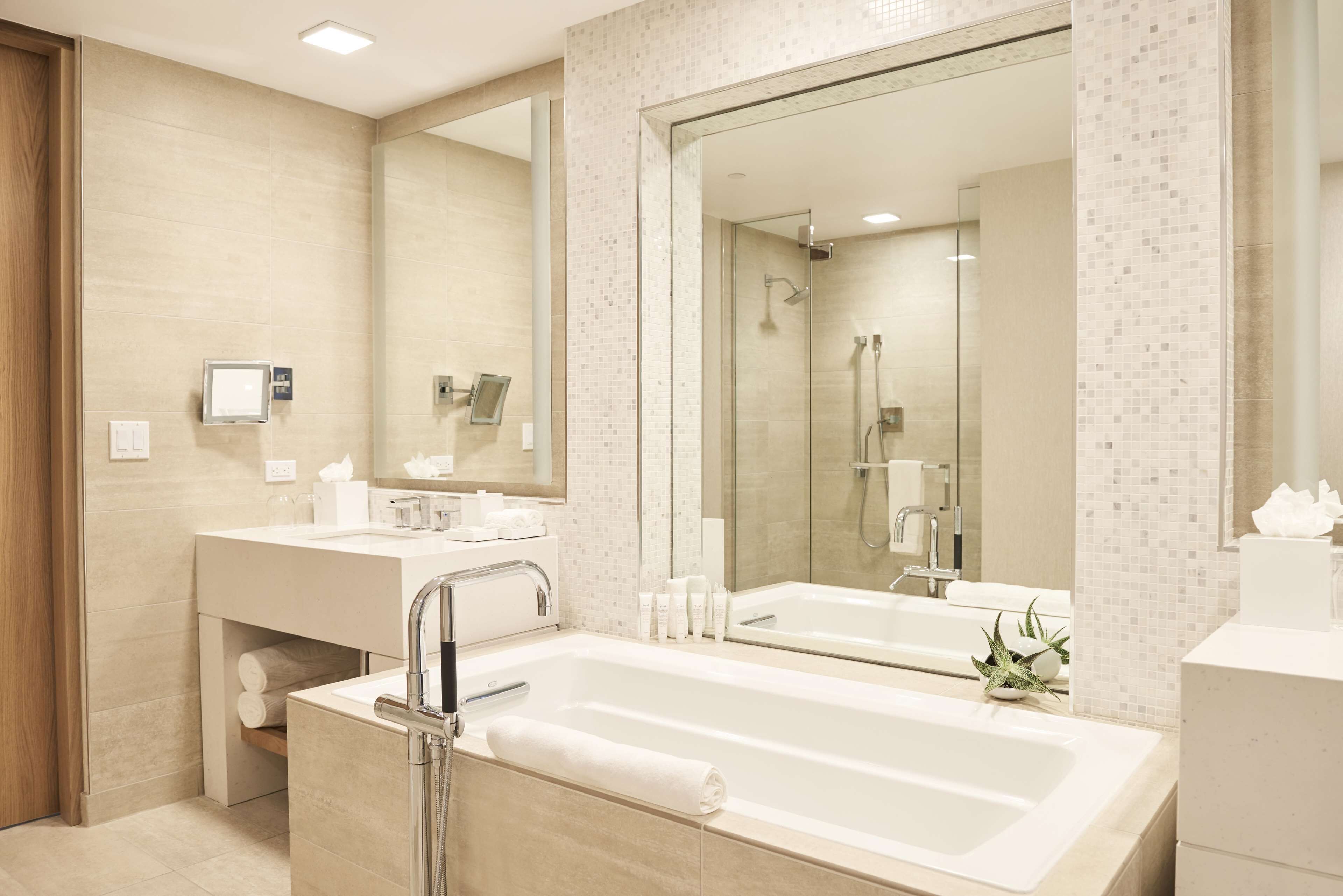 Ein modernes Badezimmer mit zwei Waschbecken, einem großen Spiegel und einer Duschkabine.