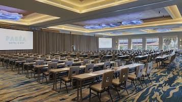 Un salón de conferencias con una pantalla grande que muestra