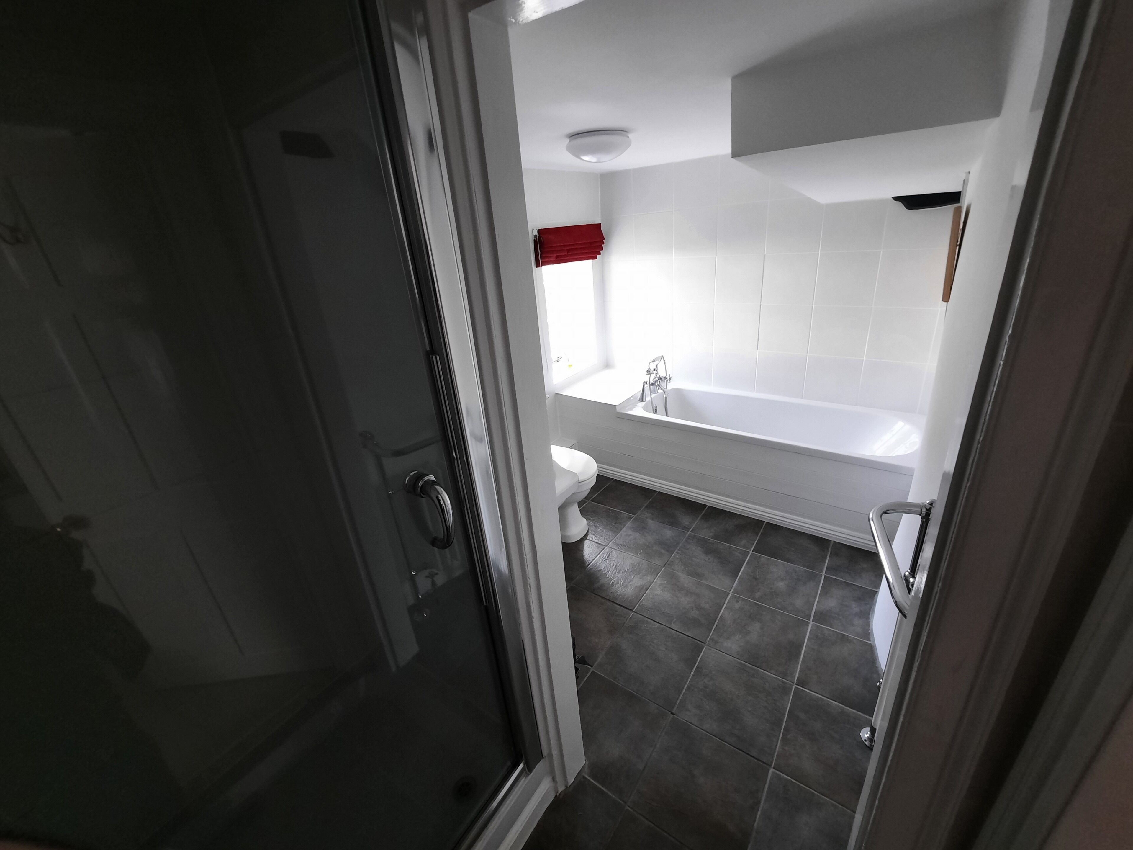 A bathroom with a bathtub, toilet, and shower area.