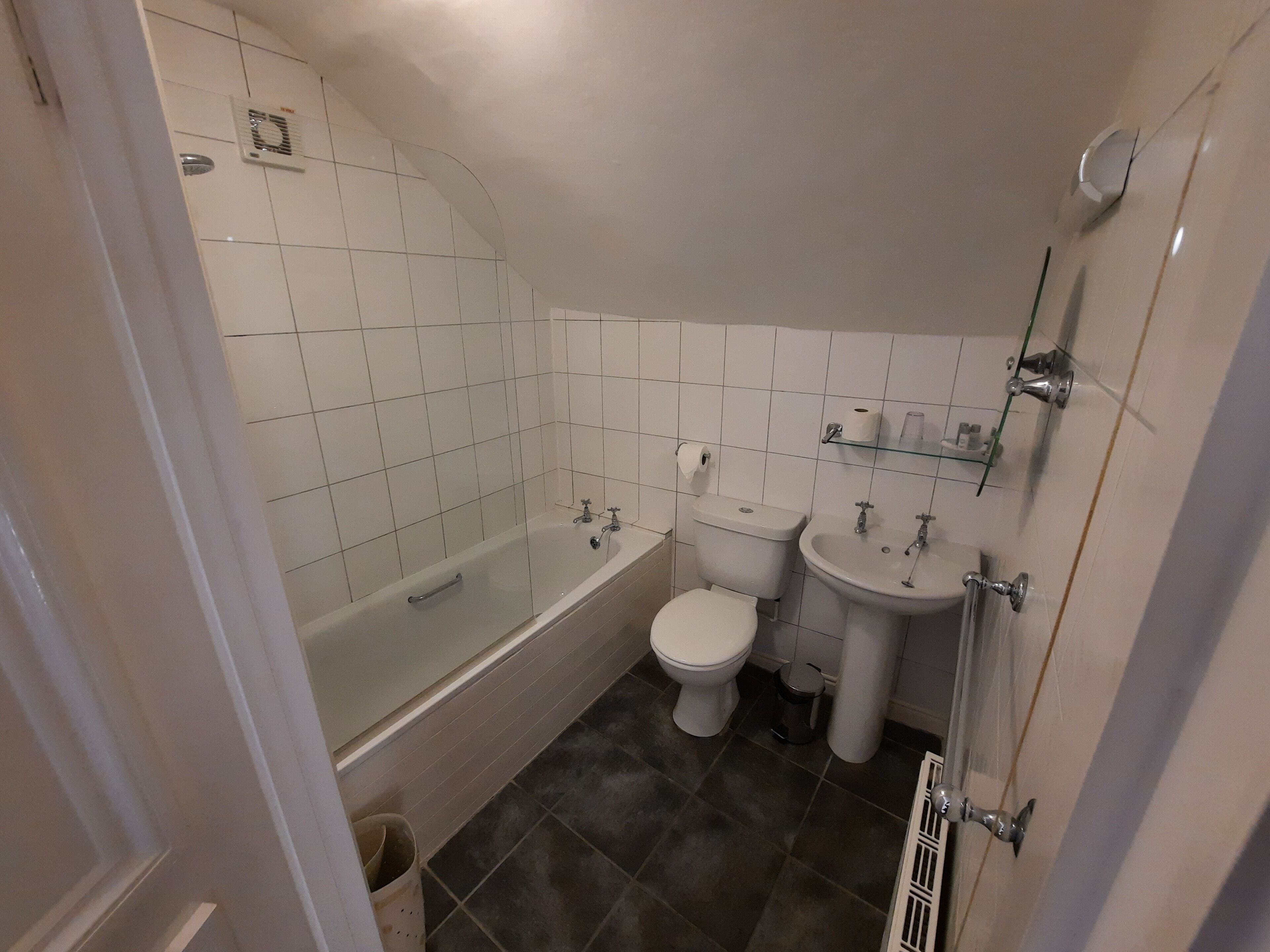 A bathroom with a bathtub, toilet, and sink.