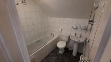 A bathroom with a bathtub, toilet, and sink.