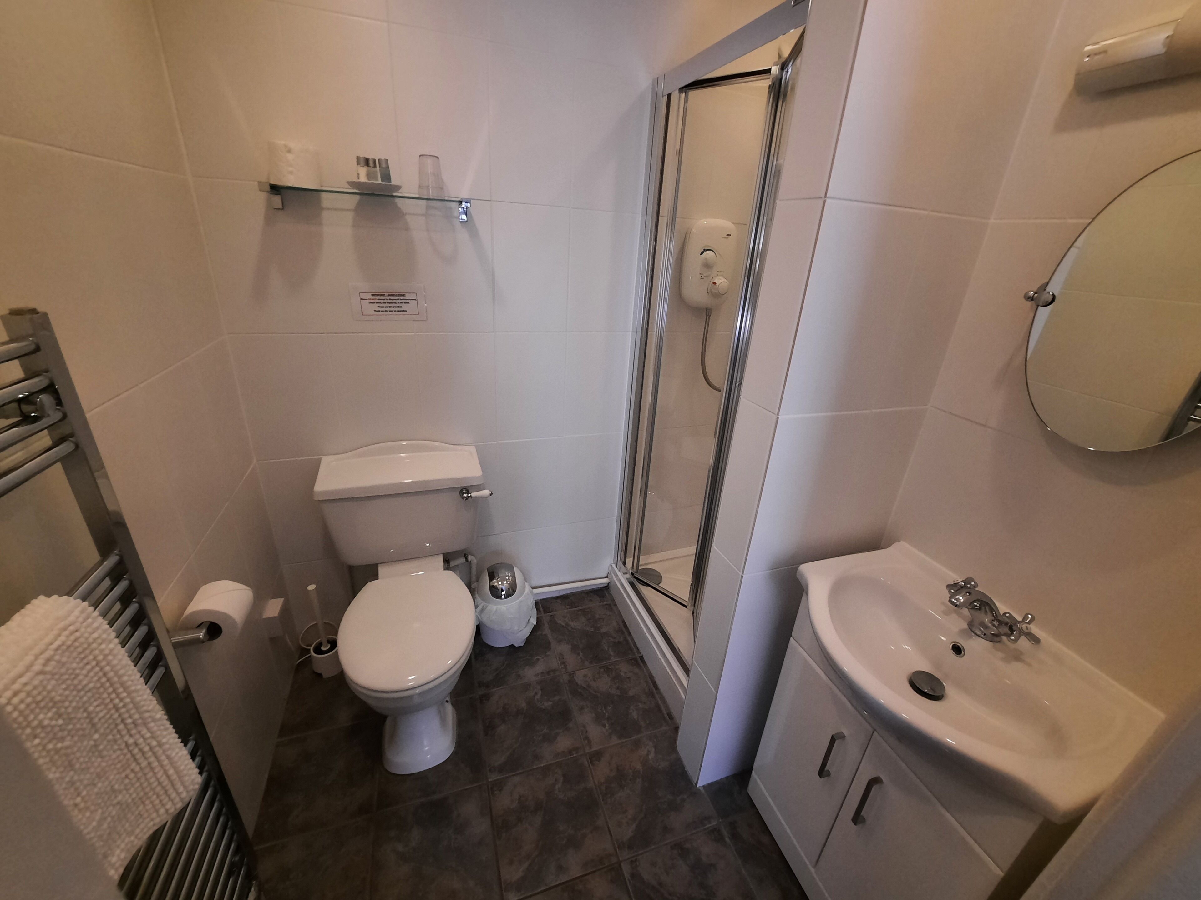 Une salle de bain avec des toilettes, une douche et un lavabo.