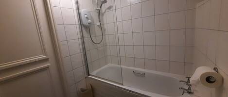 A bathroom with a bathtub, toilet, and shower.