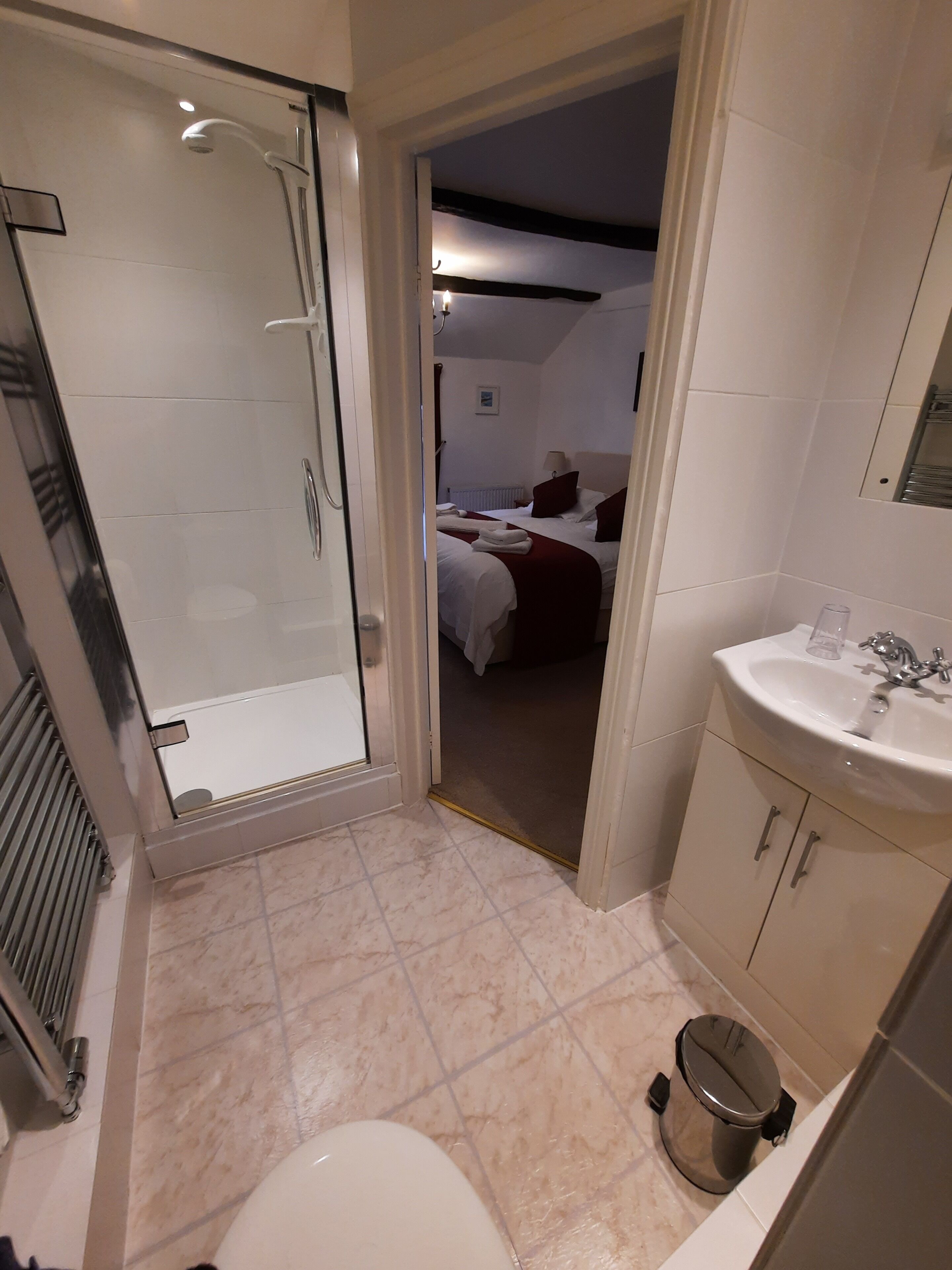 A bathroom with a shower, sink, and toilet.