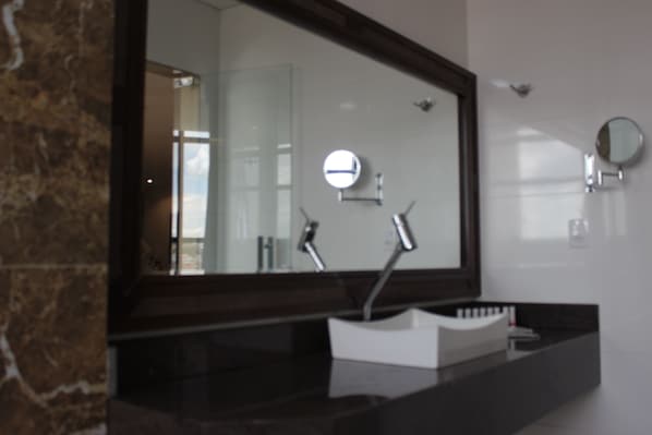 A bathroom with a large mirror, a sink, and a marble countertop. - Minas Platinum Hotel & Convention (Conselheiro Lafaiete)