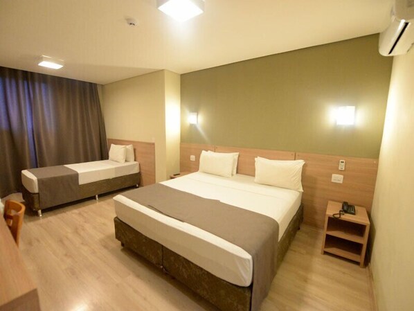 A hotel room with two beds, a wooden floor, a desk, and a nightstand. - Minas Platinum Hotel & Convention (Conselheiro Lafaiete)