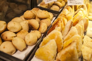 A bakery display with various baked goods. - Arlen Hotel (Pouso Alegre)