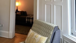 Une pièce avec un fauteuil à motifs, une porte dotée d’une fenêtre et un mur orné d’un décor en relief.