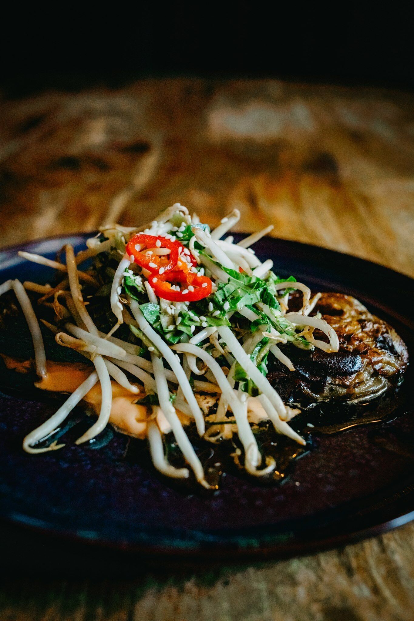 Un plato de comida con fideos, verduras y un guiso de carne oscura.