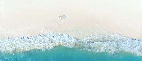 Een strand met een duidelijke grens tussen het zand en het turquoise water.