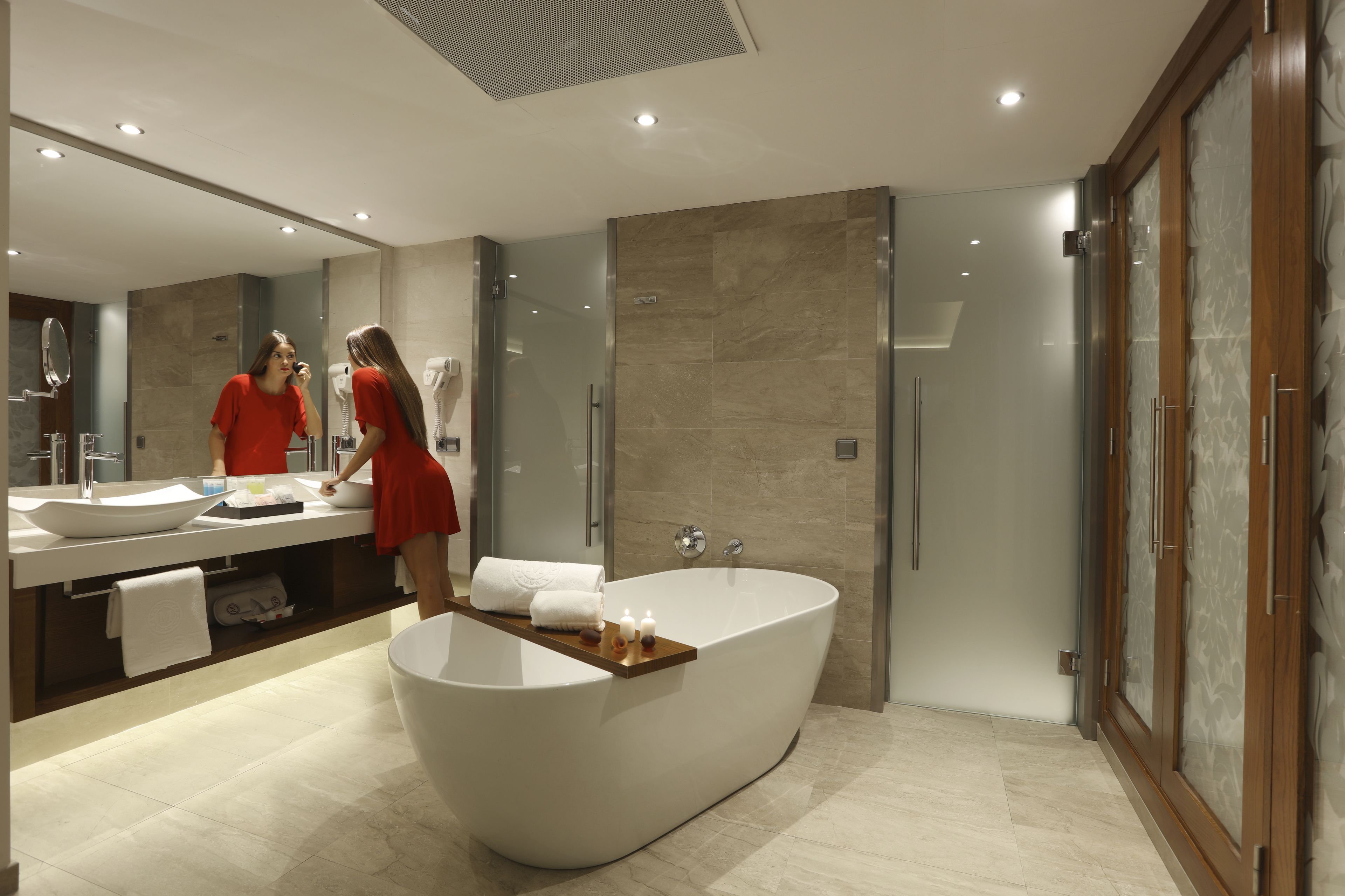 A modern bathroom with a freestanding bathtub, a large mirror, and a vanity with a sink.