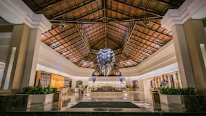 Eine großzügige Lobby mit hoher Decke, einem zentralen Brunnen und einem Empfangsbereich.
