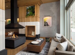 A modern living room with a fireplace, seating area, and artwork on the walls. - Kimpton Schofield Hotel by IHG (Cleveland)