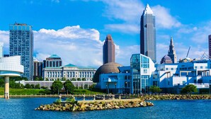 A waterfront cityscape with modern skyscrapers and a historic building.
