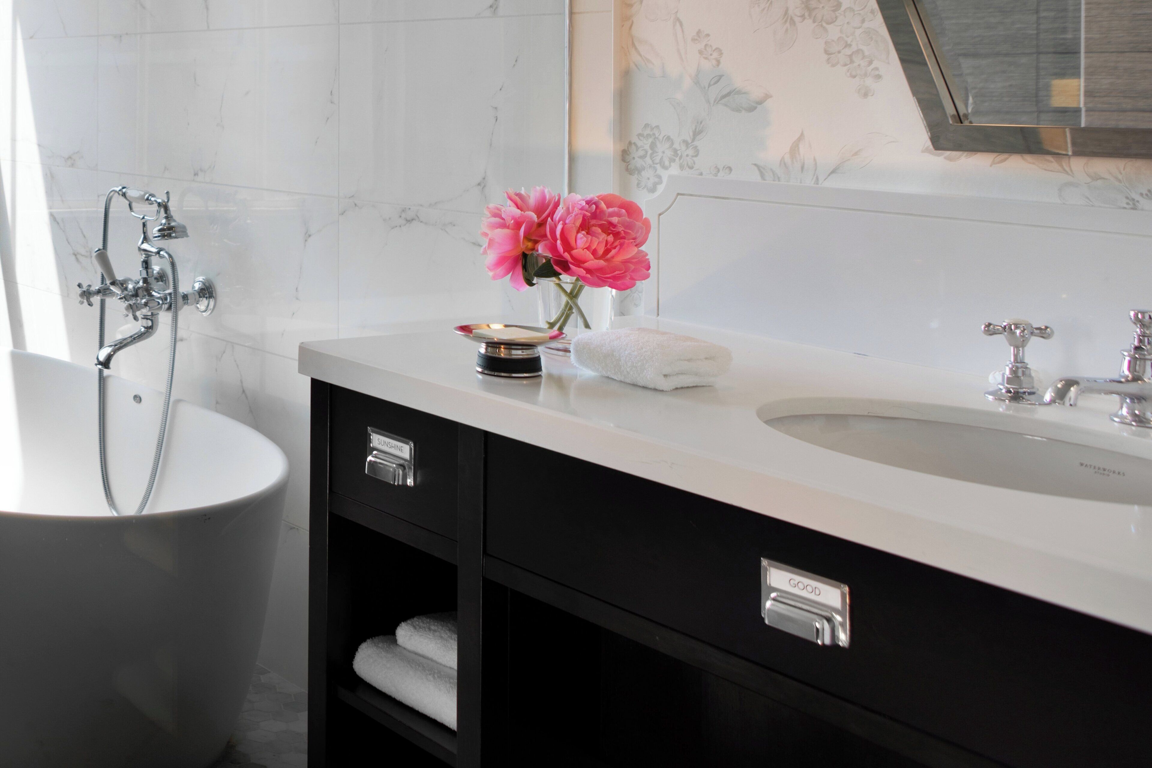 Un baño con bañera, lavabo y tocador con cajones.