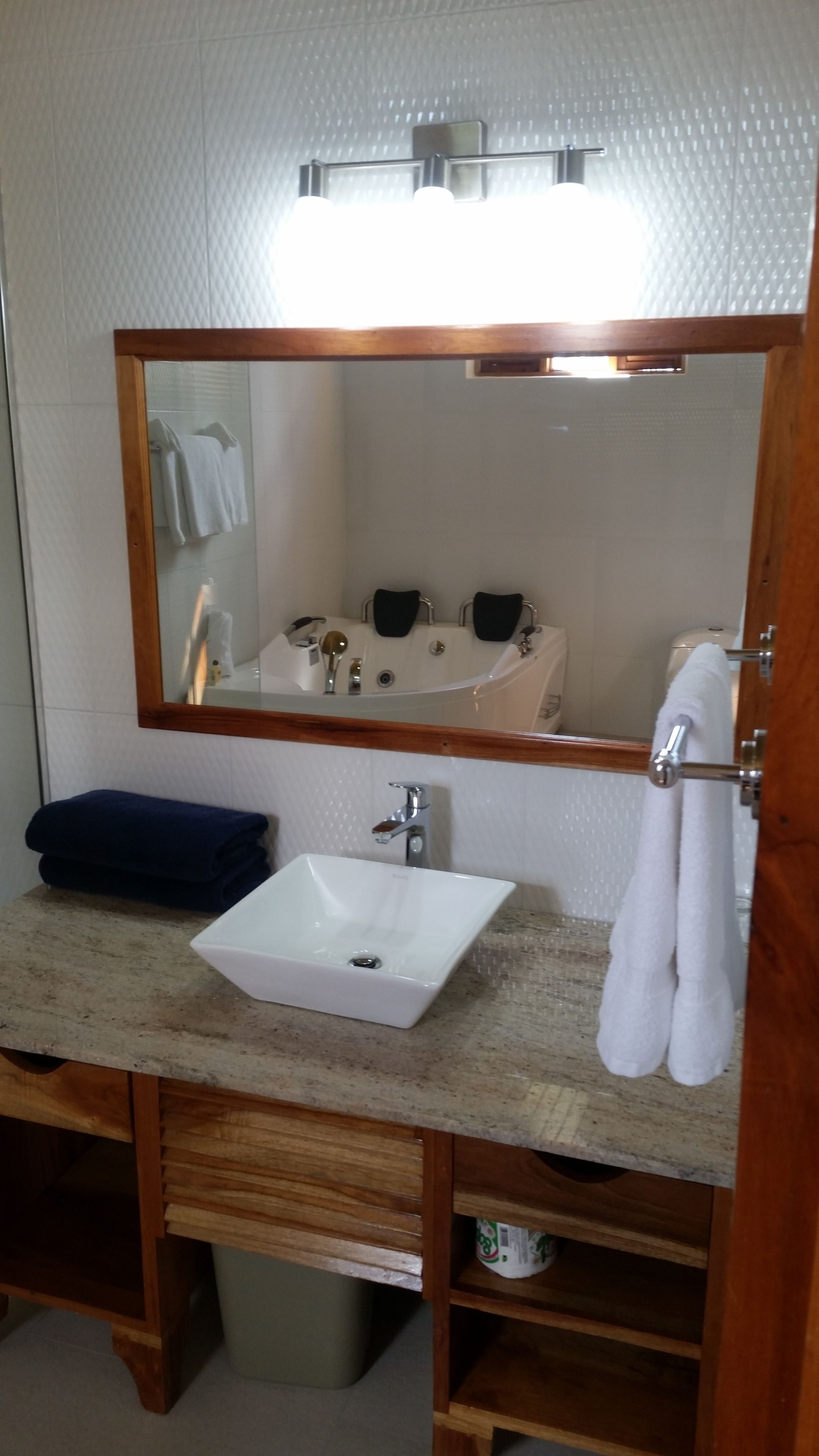 A bathroom with a white sink, a mirror above it, and a towel rack.