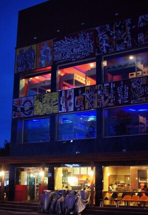 Een modern gebouw met veel ramen en een helder verlicht interieur.