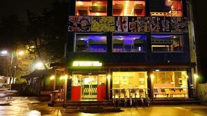 Een meerhoog gebouw met een restaurant op de begane grond en kamers op de bovenverdiepingen.