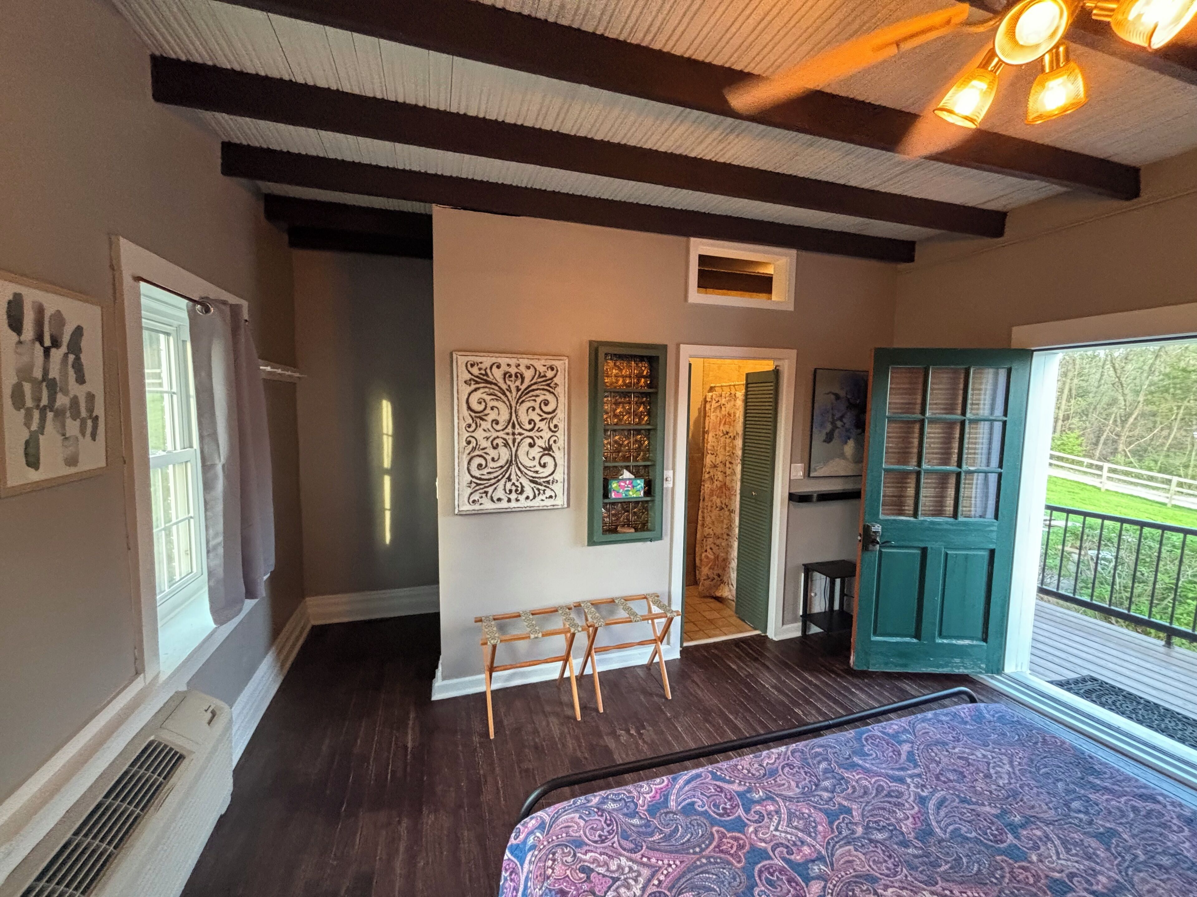 A room with a wooden bench, a door with a view, and a ceiling fan.