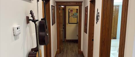A hallway with wooden doors, a guitar, and a sign that says "EXIT".