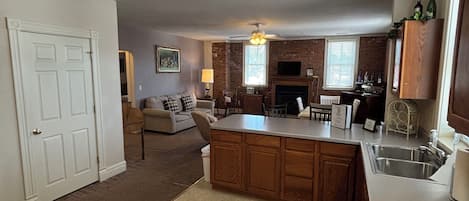 A kitchen with a central island, a ceiling fan, and a fireplace.