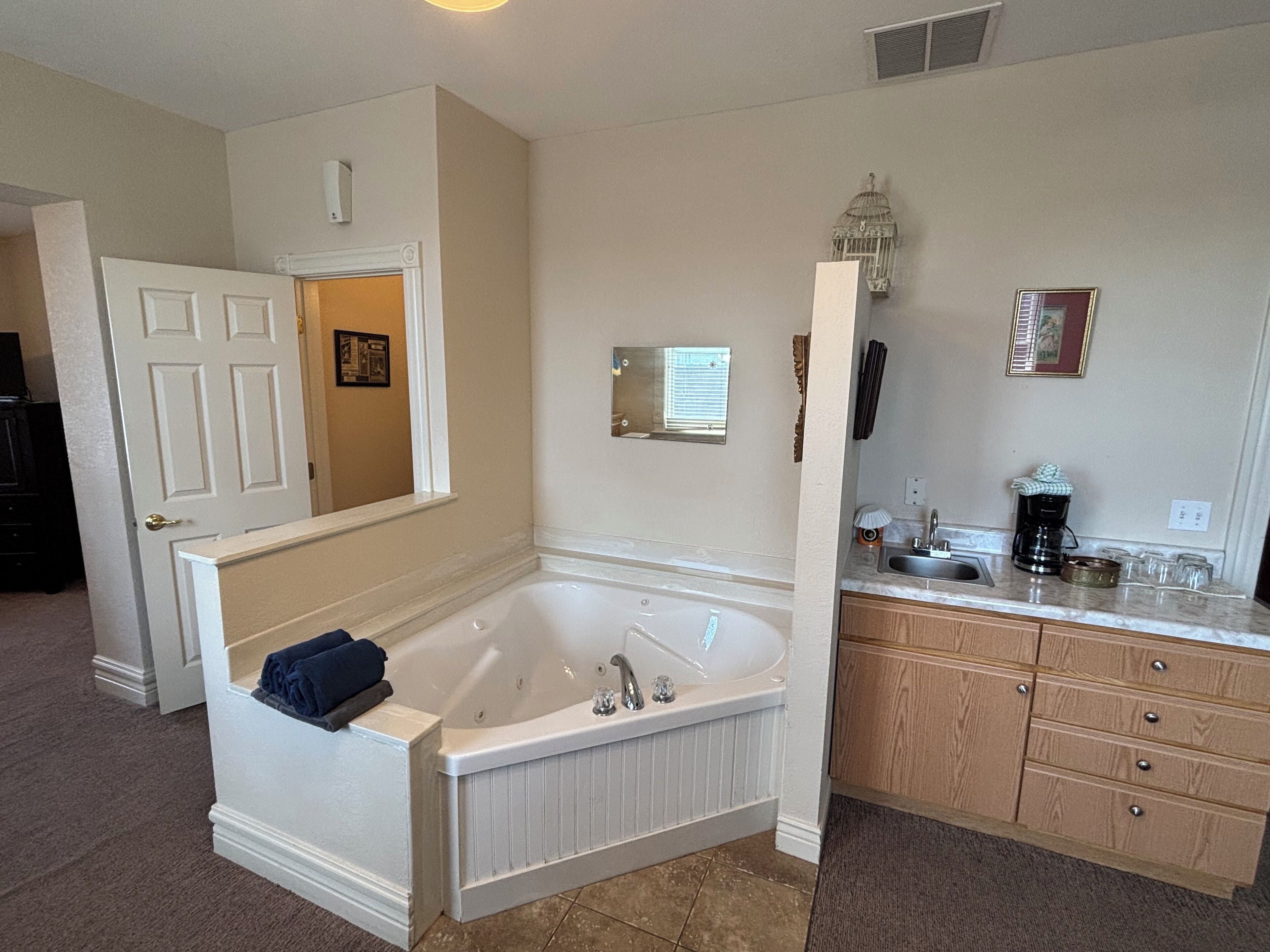 A bathroom with a freestanding bathtub, a vanity with a sink, and a mirror.