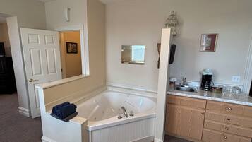 A bathroom with a freestanding bathtub, a vanity with a sink, and a mirror.