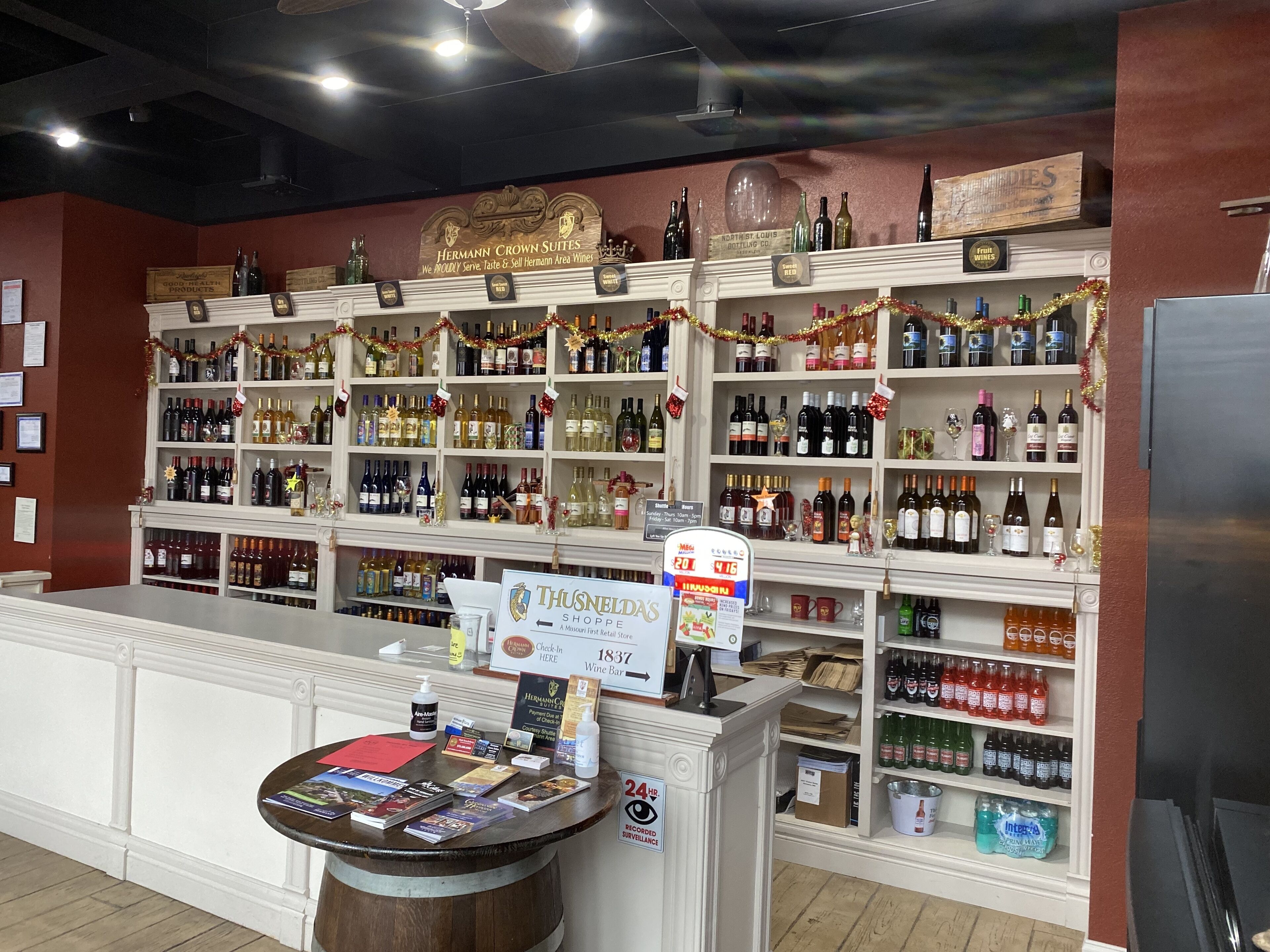 A liquor store with shelves of various bottles and a counter with a sign for Thunstead's Shoppe.