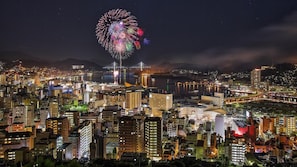 Une vue nocturne d’une ville, avec un pont imposant et un feu d’artifice.