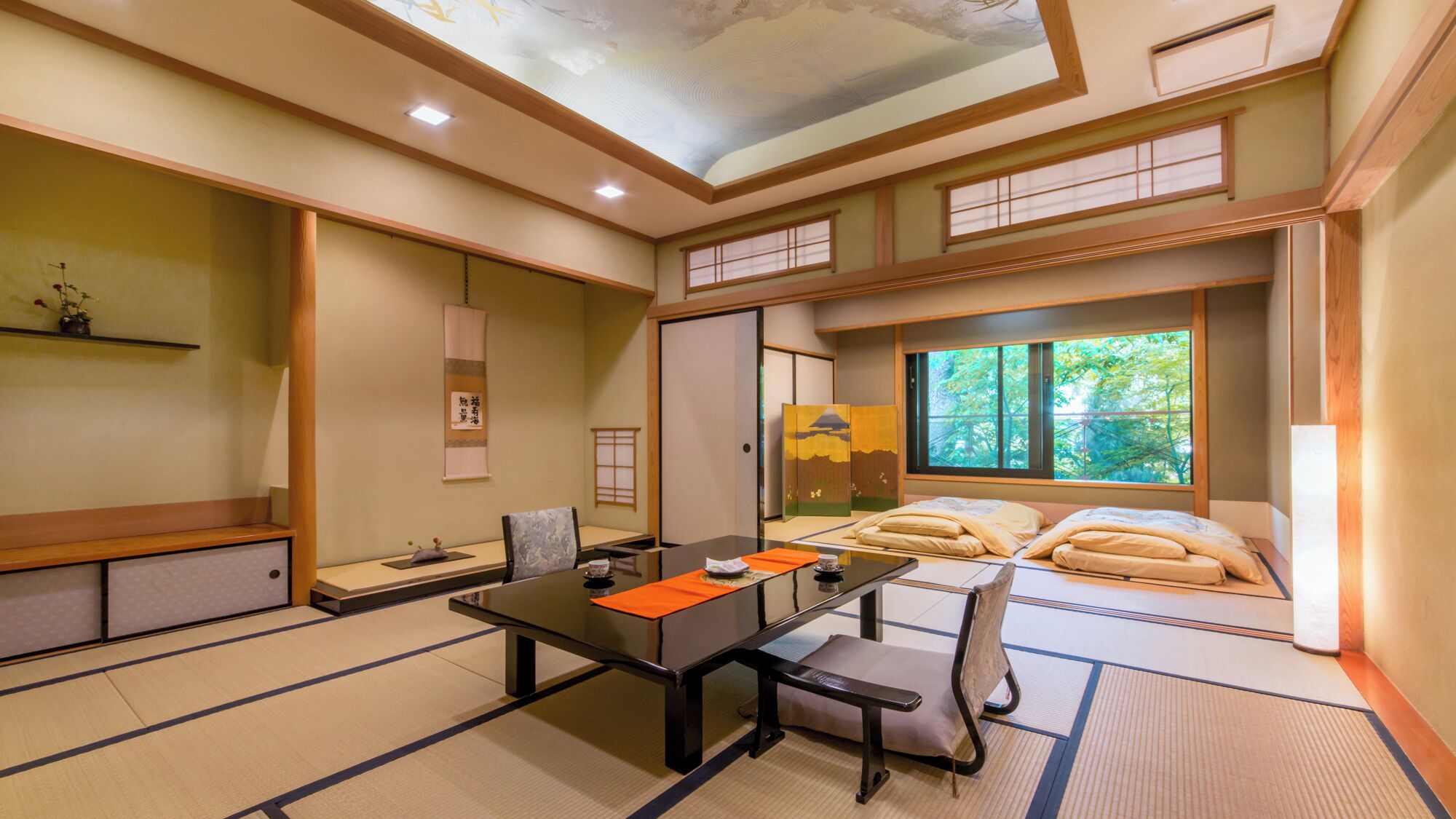 A traditional Japanese-style room with tatami flooring, a low table, and a futon bed.