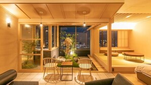 Ein modernes Interieur mit Essbereich, Sitzgelegenheiten und Blick auf die nächtliche Stadt.