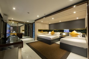Una habitación de hotel moderna con dos camas, un escritorio con computadora y televisión.
