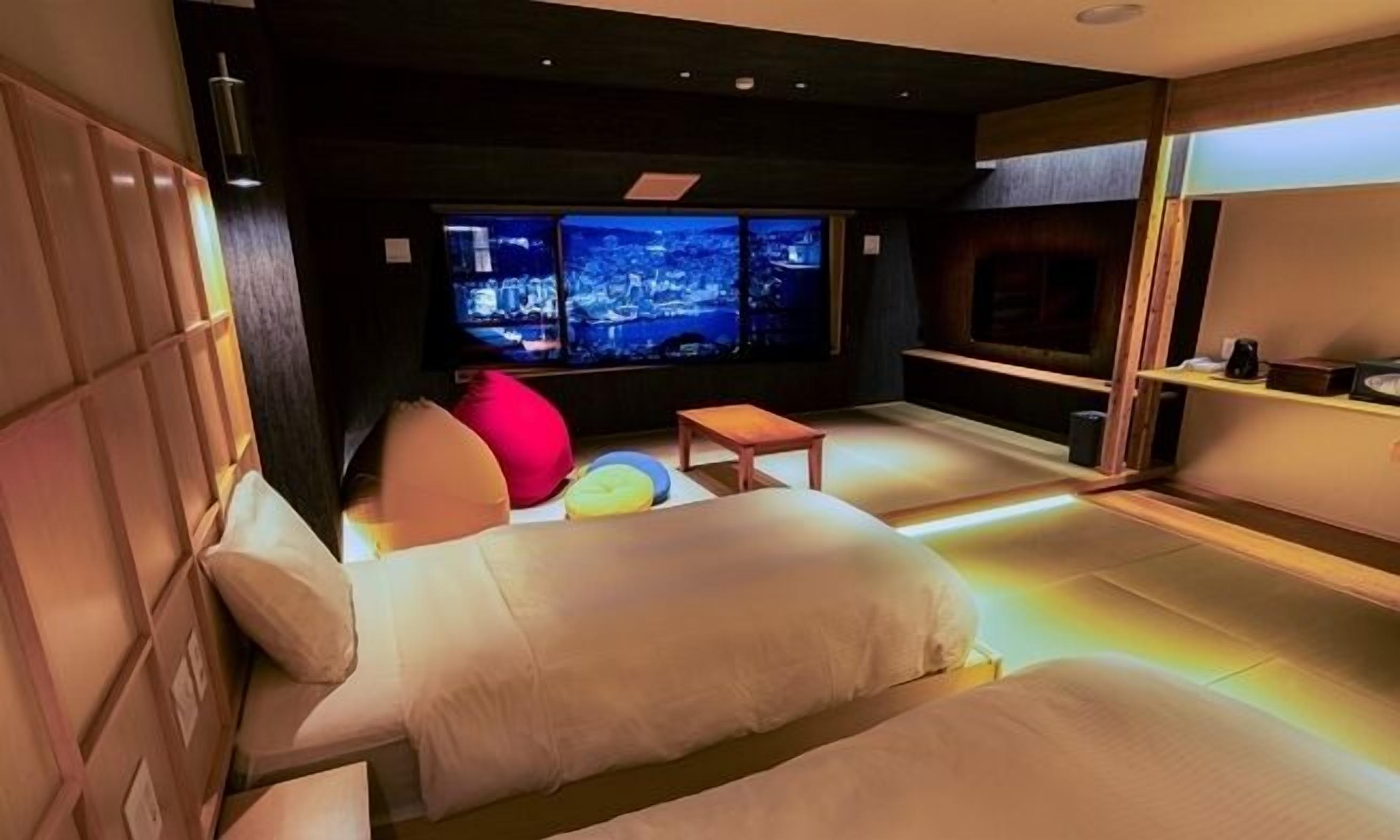 A modern room with a sofa, a small table, and a TV displaying a cityscape.