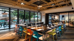 A modern conference room with a long table, colorful chairs, and large windows offering a view of the outdoors. - The Kuala Lumpur Journal (Kuala Lumpur)
