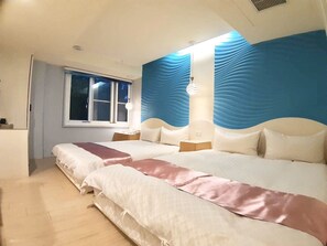A hotel room with a large bed, a window, and a blue textured wall. - Travel Young (Kaohsiung)
