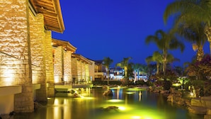 A resort with a pool, stone buildings, and palm trees. - Olympic Lagoon Resort – Ayia Napa (Ayia Napa)