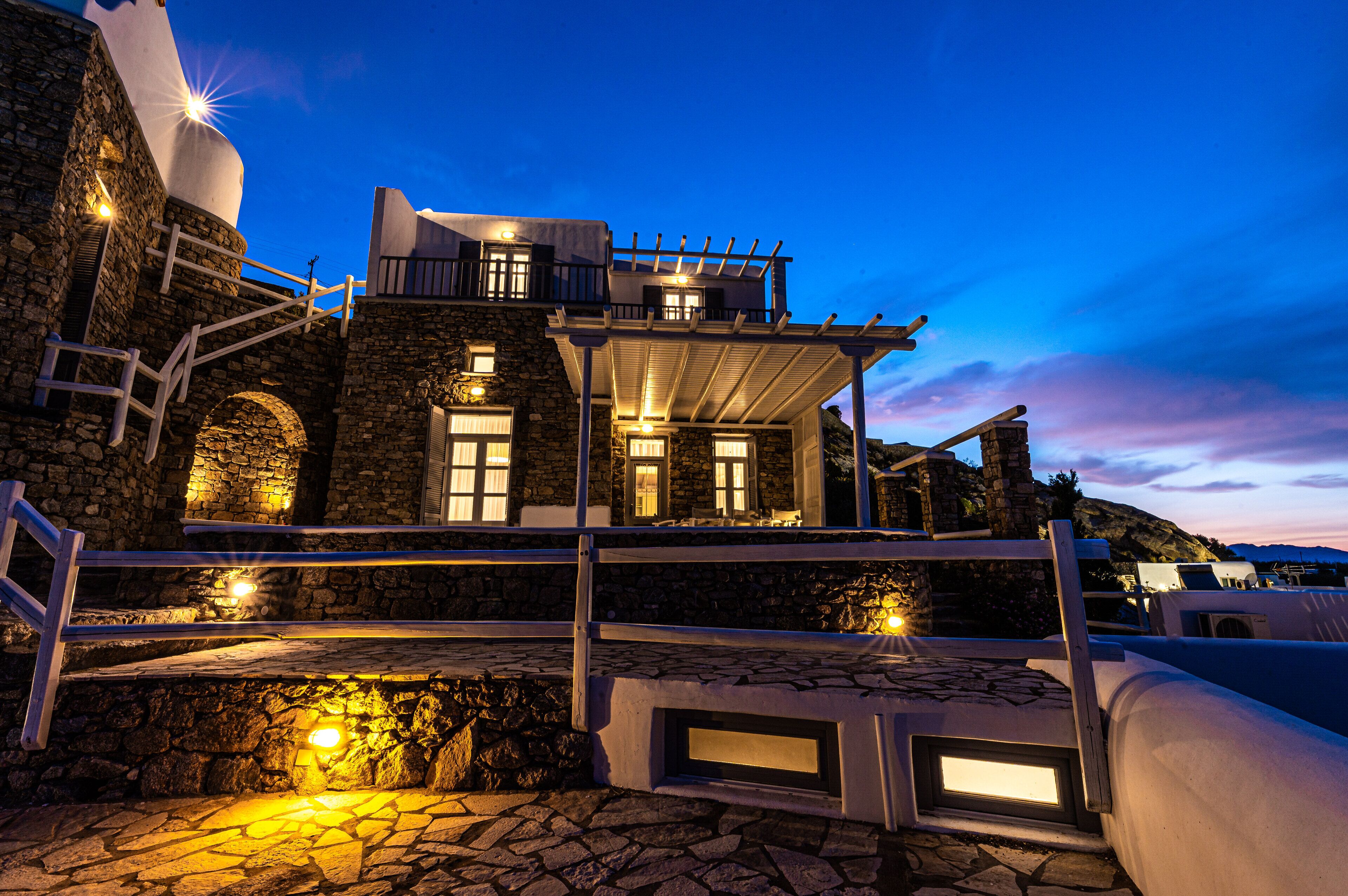 A stone building with a balcony and steps leading up to it.