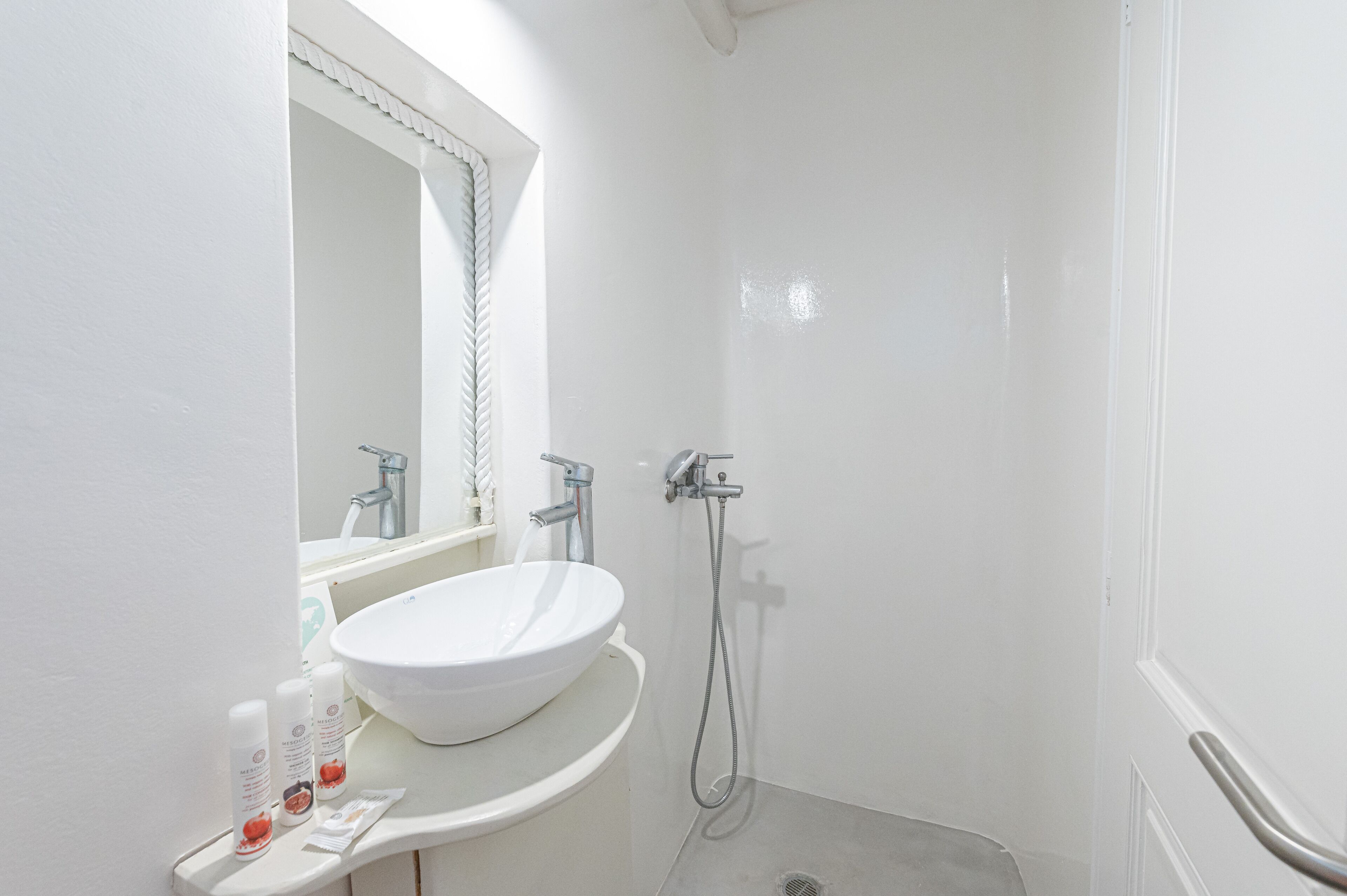 A bathroom with a white sink, mirror, and shower.