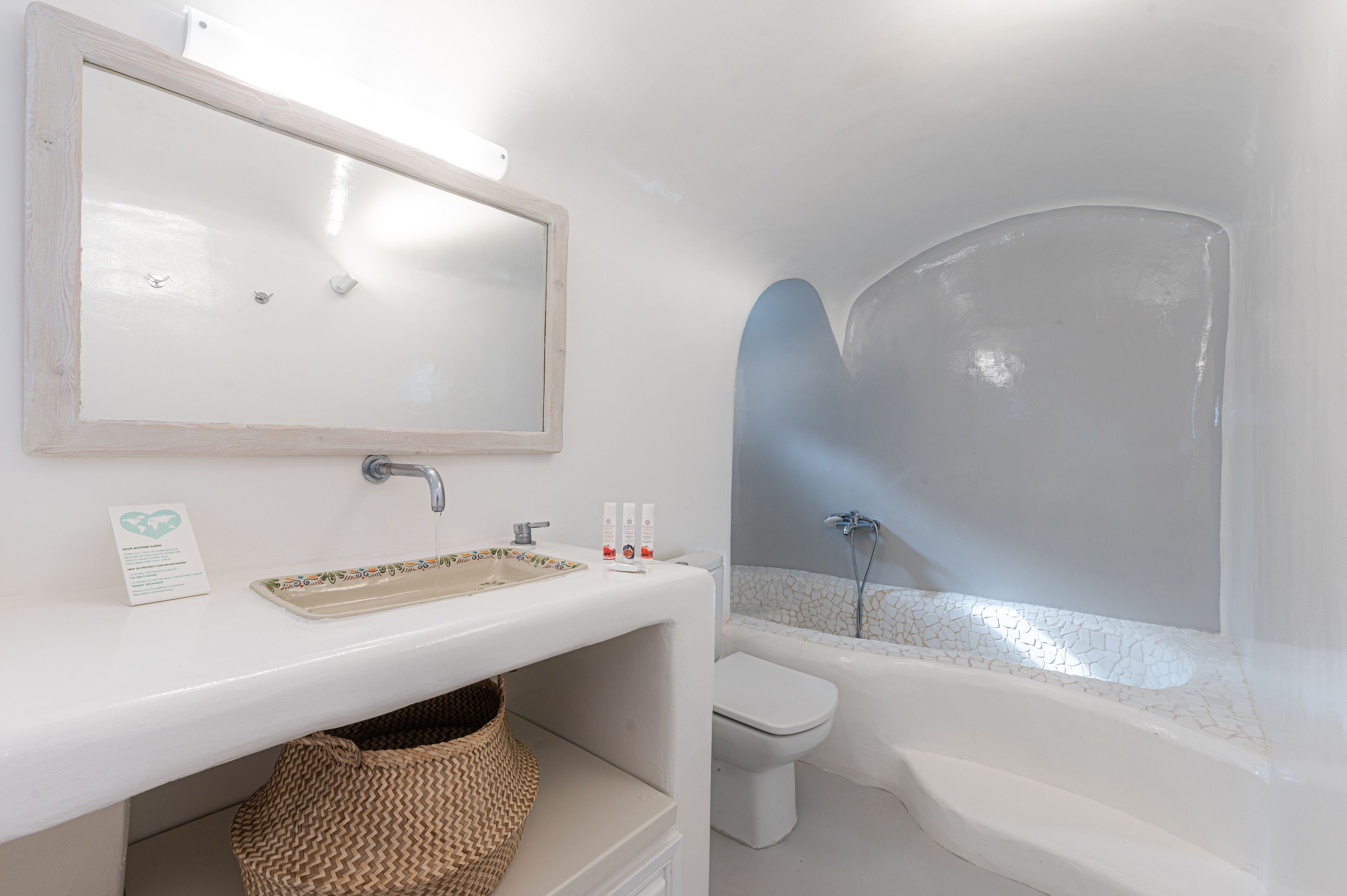 A bathroom with a white sink, mirror, and bathtub.