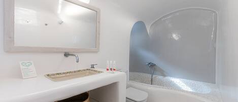 A bathroom with a white sink, mirror, and bathtub.