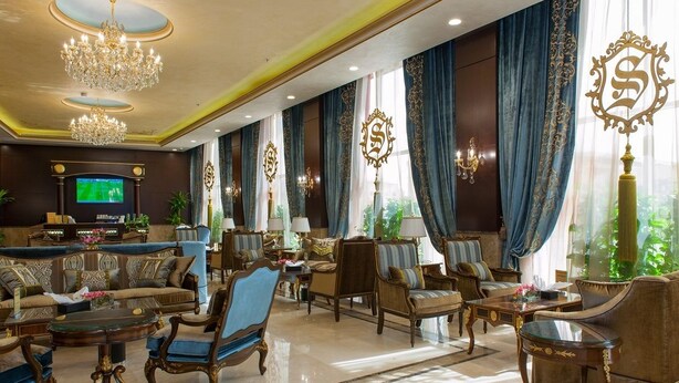 A luxurious lobby with a large seating area, chandeliers, and a television screen. - Suite Inn Al Riyadh  - سويت ان الرياض (Riyadh)