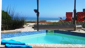 Ein Schwimmbad mit Blick auf Strand und Meer.