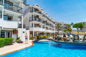 A hotel with multiple balconies, a swimming pool, and outdoor seating areas. - Joker Side Hill Suite Hotel (Manavgat)