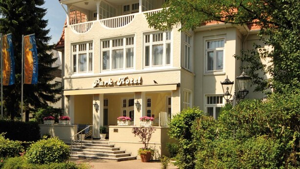 A two-story hotel with a balcony on the upper floor, a sign reading "Park Hotel," and a staircase leading to the entrance. - Park-Hotel Timmendorfer Strand (Timmendorfer Strand)