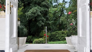 A hotel entrance with a white door, a doormat, and potted plants. - Park-Hotel Timmendorfer Strand (Timmendorfer Strand)